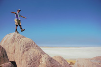 一个人在砂岩山顶上行走并保持平衡